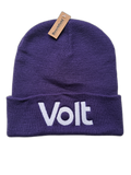 Eine dunkelviolette Strickmütze mit umgeschlagenem Rand. Auf dem Rand ist in weißer Schrift das Wort 'Volt' aufgestickt. An der oberen Mitte der Mütze ist ein braunes Etikett mit der schwarzen Aufschrift 'Beechfield'.